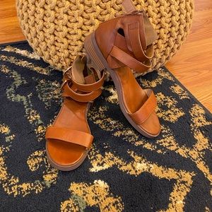 Brown leather Sandals with an ankle strap.